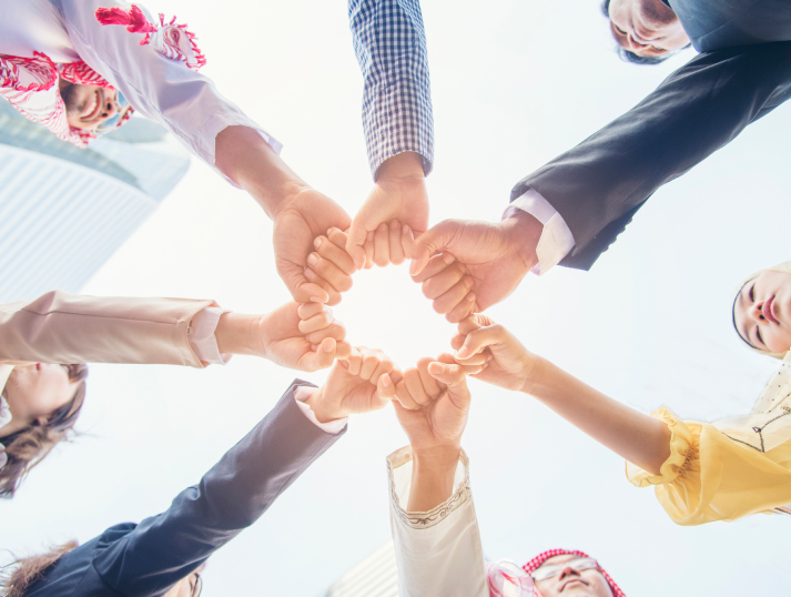 A diverse team joining hands in a circle